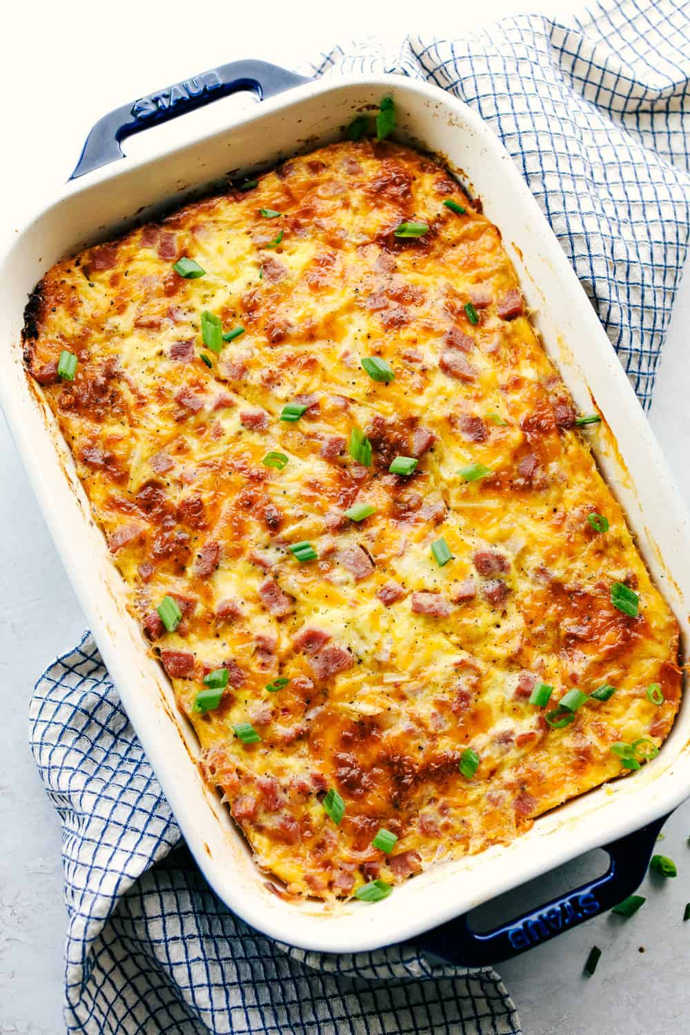 The Best Breakfast Casserole is a thick and creamy egg base with shredded potatoes, chunks of ham and flavorful cheese blends that bakes up in no time. Make ahead or enjoy the morning of during the holidays! Breakfast casserole baked in a casserole dish.