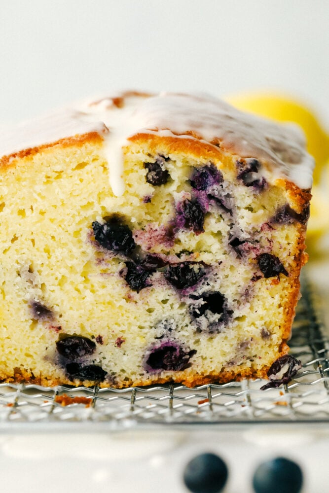 Blueberry Lemon Pound Cake! This pound cake is made lighter by using greek yogurt, and is loaded up with lemon flavor thanks to zest and fresh lemon juice! Juicy blueberries are baked right in. All drizzled with a luscious lemon glaze. The cross section of the blueberry lemon cake.