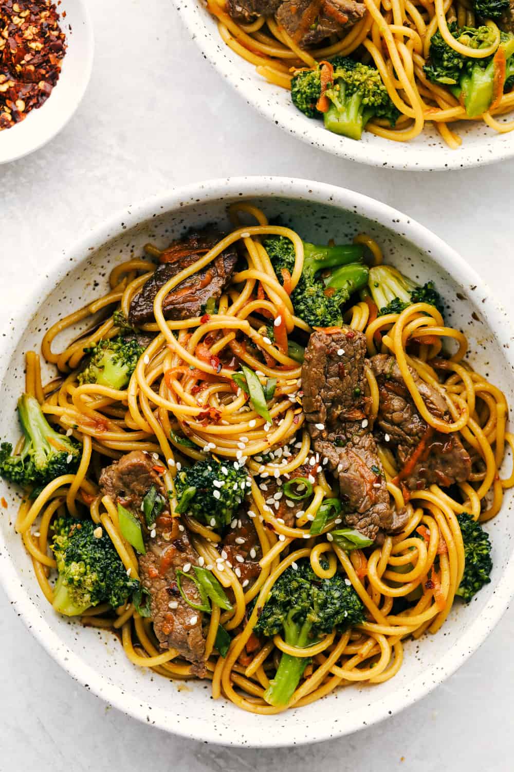 Beef and Broccoli Lo Mein has melt in your mouth tender beef with broccoli, carrots, and noodles. The sauce adds such amazing flavor to this incredibly easy meal! Beef and broccoli lo mein in a bowl.
