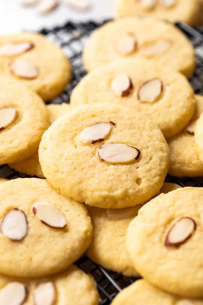 Almond Cookies are buttery, soft and chewy these cookies are made with almond flour, almond extract, and topped with slices of toasted almond! Almond cookies on a cookie rack.