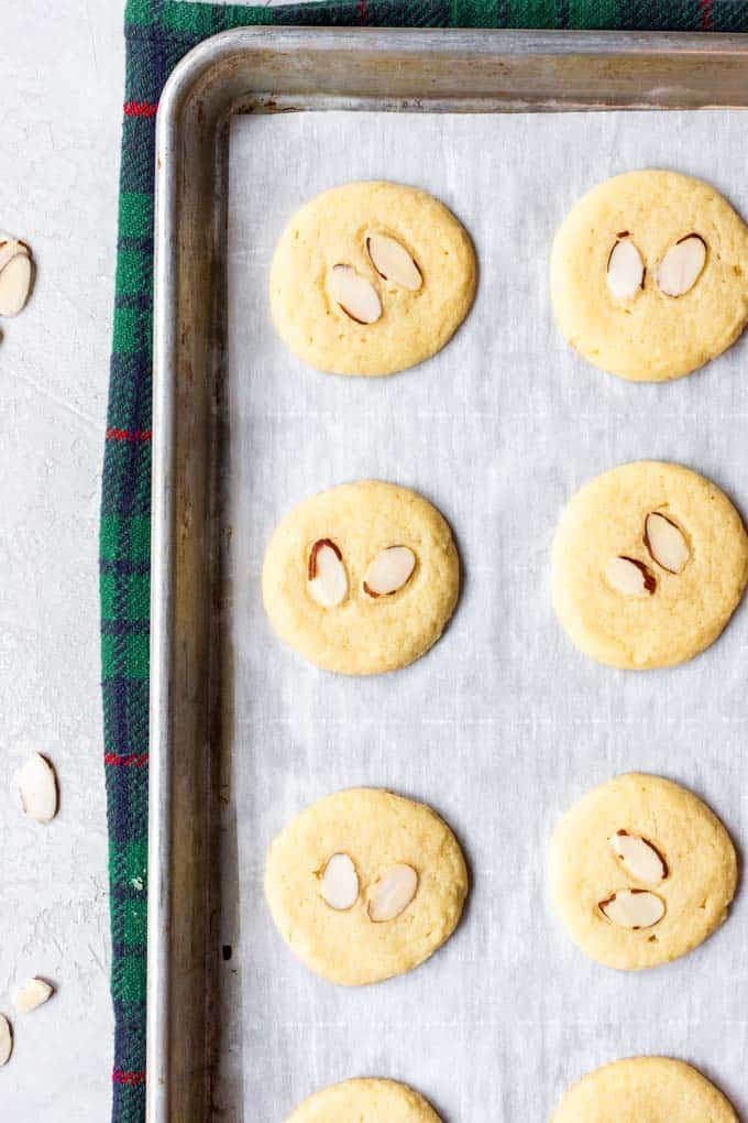 Almond Cookies are buttery, soft and chewy these cookies are made with almond flour, almond extract, and topped with slices of toasted almond! Almond cookies on a baking sheet.