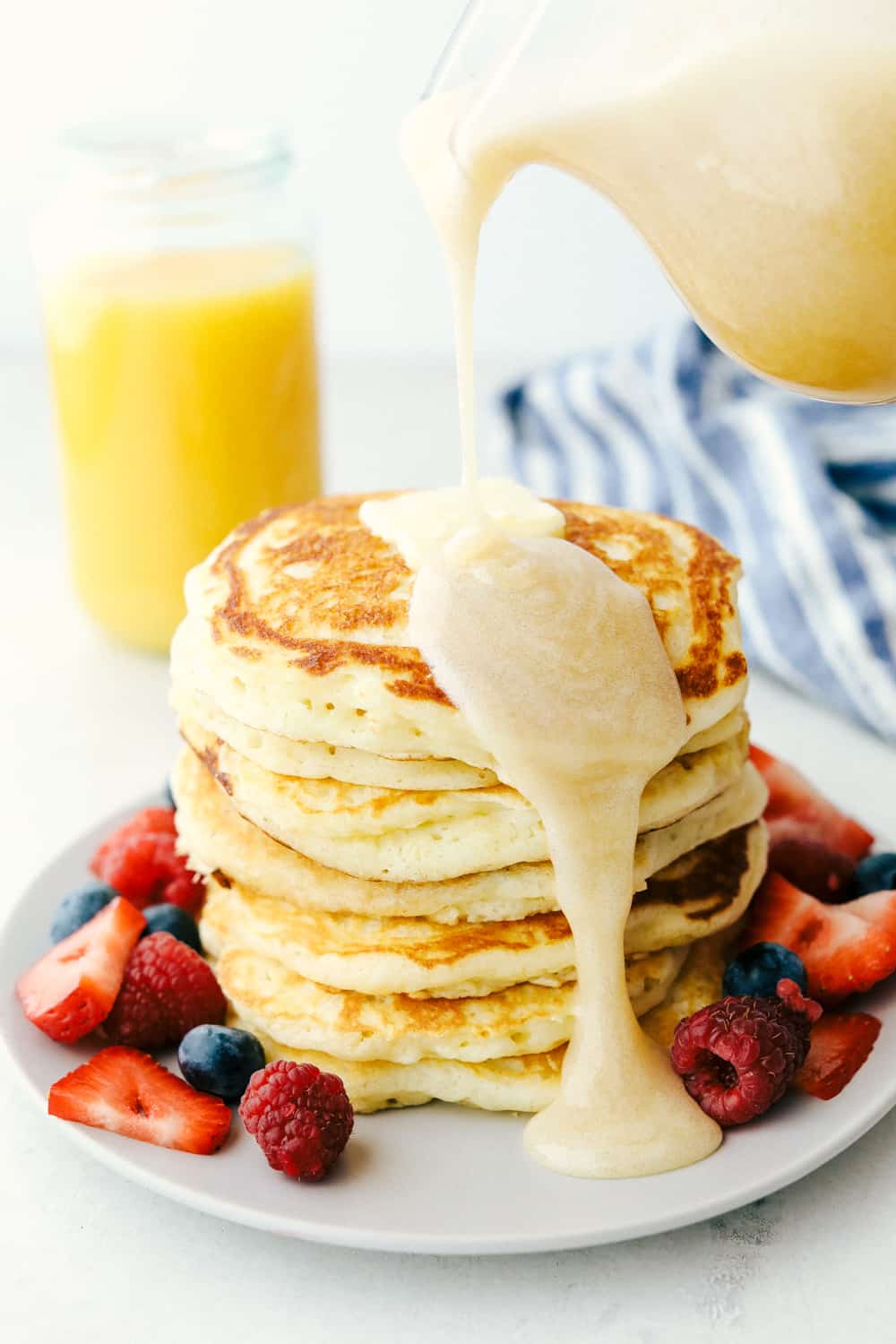 The best and only Buttermilk Pancake recipe that you will ever need! Perfectly fluffy every single time! Soft and pillowy with a tender crumb, these are going to be a hit at the breakfast table. Buttermilk syrup being poured over buttermilk pancakes.