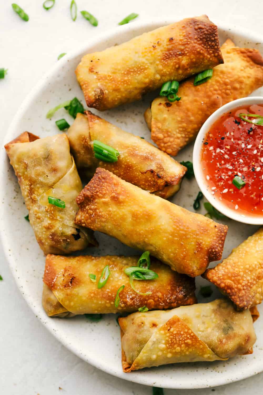 Egg Roll lovers, this Crispy Air Fryer Egg Roll Recipe is for you! Crispy, crunchy outside, tender filling inside, without the extra fat of frying or drying out from oven cooking. These are what you have been waiting for! Air Fryer Egg Rolls on a platter with dipping sauce.