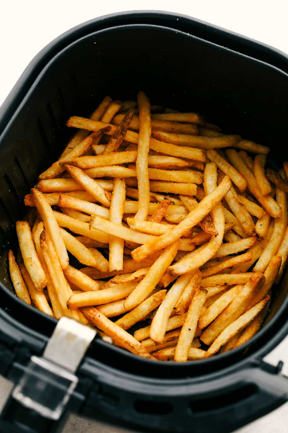 These Air Fryer Frozen French Fries come out exactly like your favorite fast food fries! They are crispy, golden on the outside and perfectly soft on the inside. So much better than frying or baking! Frozen French Fries cooked in the air fryer.