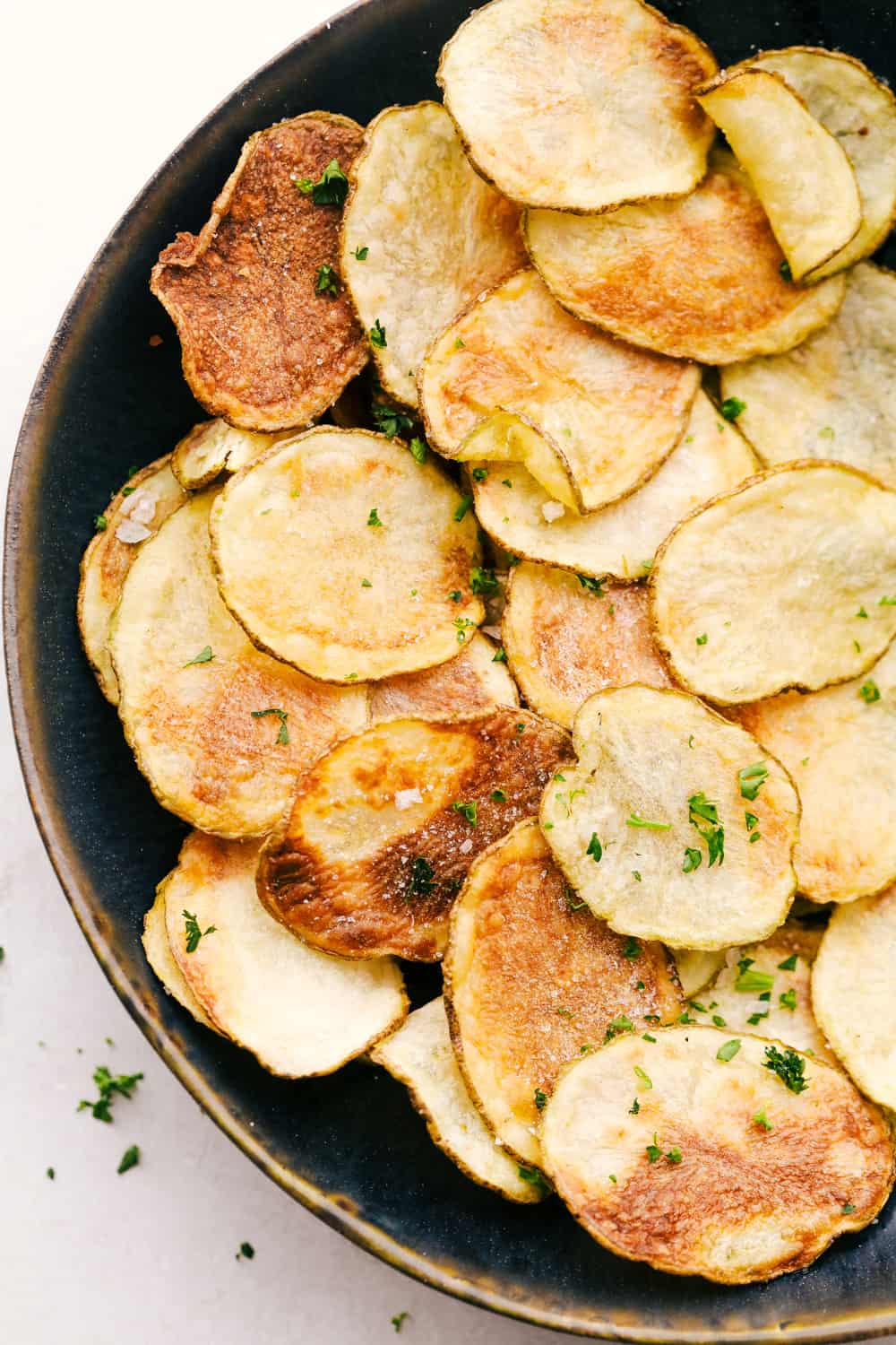 Air Fryer Potato Chips are a chip lovers dream come true! Now you can have all the chips, and none of the guilt! Air Fryer potato chips on a plate.