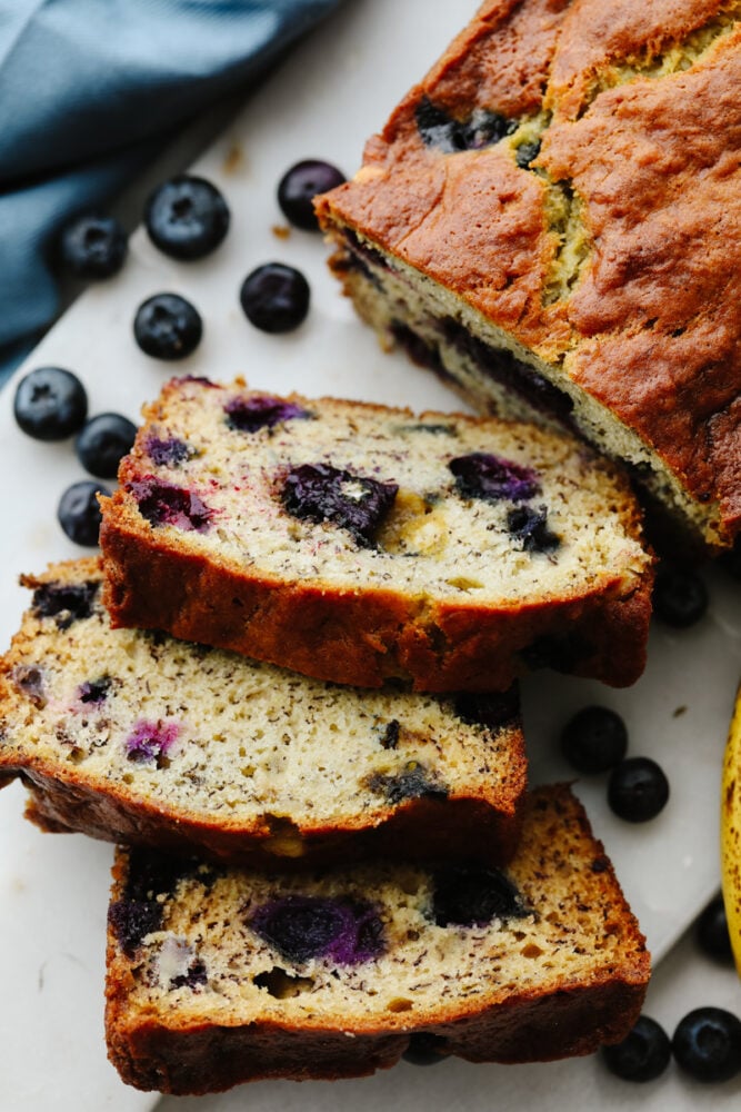 This staple blueberry banana bread recipe has the perfect combination of bananas and fresh blueberries. It is so moist, delicious, and super simple to make! 3 slices cut from a loaf of banana bread.